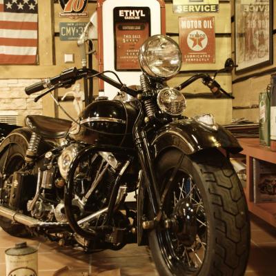 Eine Harley Davidson steht in einer Oldscool Werkstadt. Auf dem Boden liegt benutztes Werkzeug.